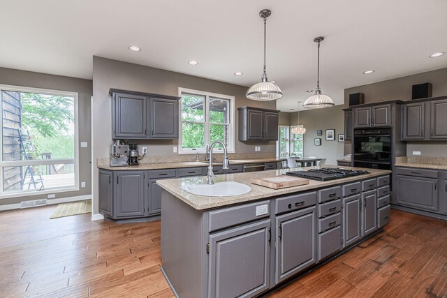 2416 Cimarron Dr, Columbia, MO 65203 - kitchen featuring gray cabinets, a sink, a kitchen island, black appliances, and wood finished floors