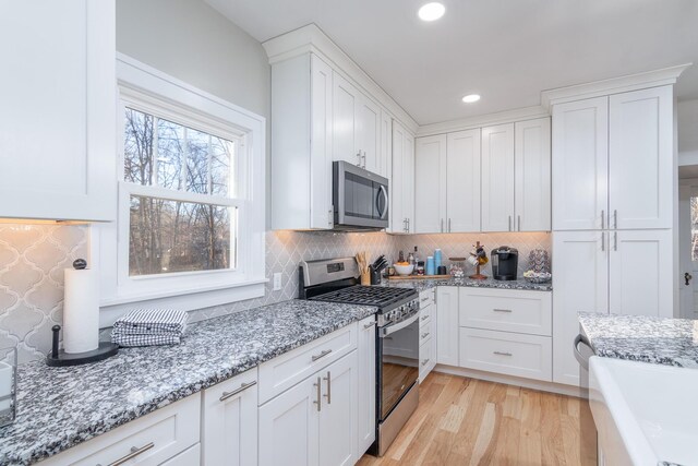 303 S Glenwood Ave, Columbia, MO 65203 - kitchen featuring appliances with stainless steel finishes, white cabinetry, recessed lighting, tasteful backsplash, and light wood-style flooring