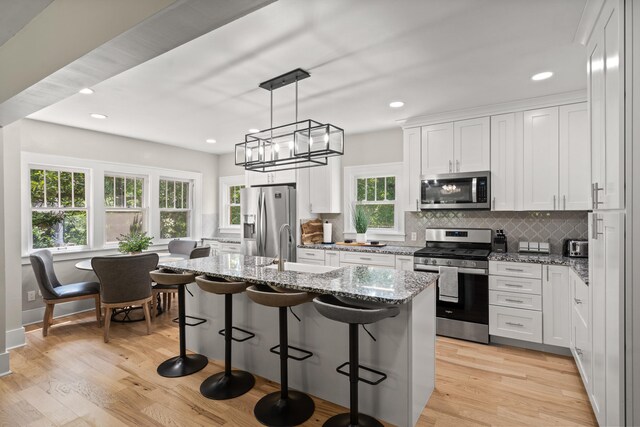 303 S Glenwood Ave, Columbia, MO 65203 - kitchen featuring stainless steel appliances, light wood-style flooring, backsplash, white cabinetry, and recessed lighting