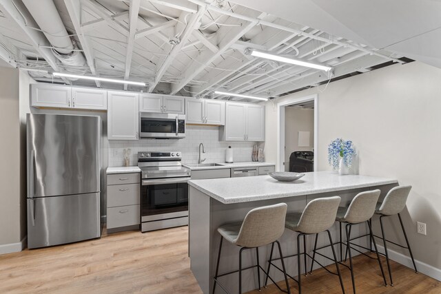 303 S Glenwood Ave, Columbia, MO 65203 - kitchen with stainless steel appliances, a breakfast bar area, light countertops, a peninsula, and white cabinetry