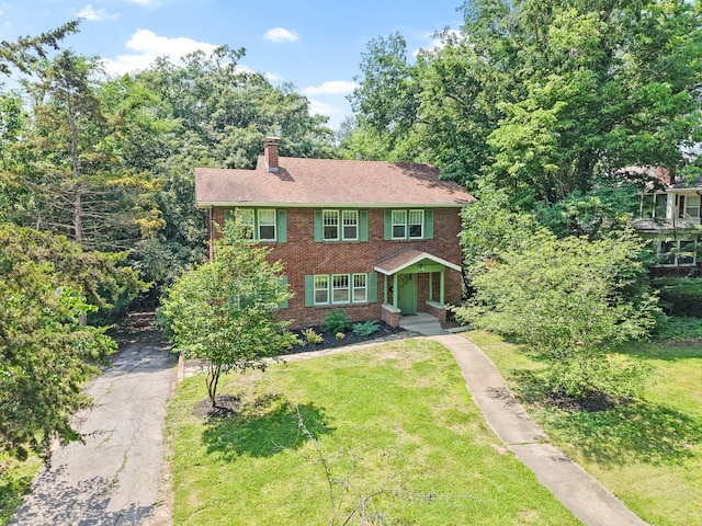 303 S Glenwood Ave, Columbia, MO 65203 - colonial-style house with asphalt driveway, brick siding, a chimney, and a front lawn