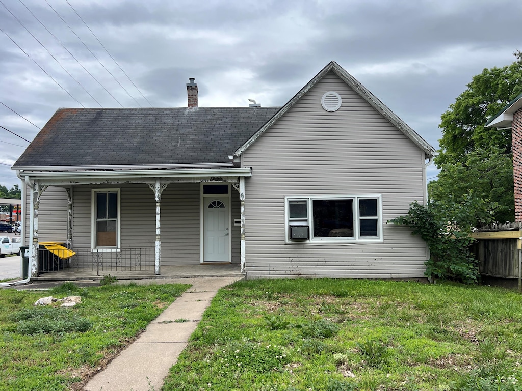 412 E Walnut St, Boonville, MO 65233 - view of front of home with a porch, a chimney, cooling unit, and roof with shingles