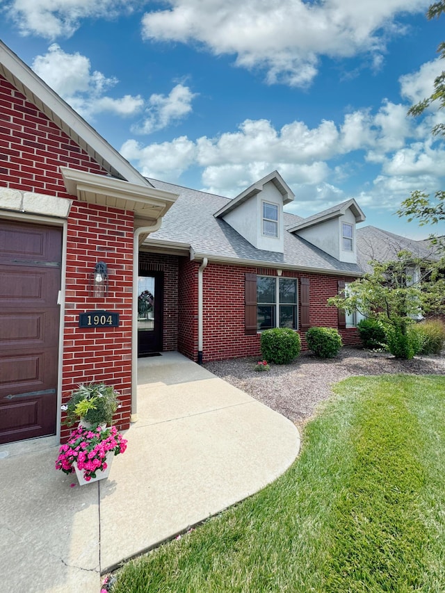 1904 Talco Dr, Columbia, MO 65201 - entrance to property with brick siding, roof with shingles, a lawn, and a garage