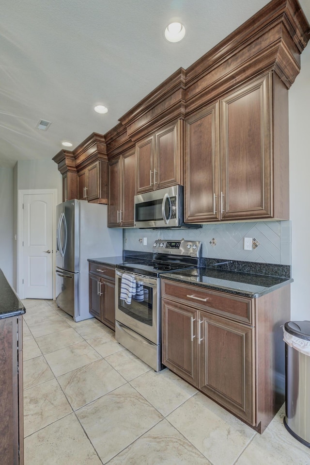 1904 Talco Dr, Columbia, MO 65201 - kitchen with appliances with stainless steel finishes, dark stone counters, and decorative backsplash