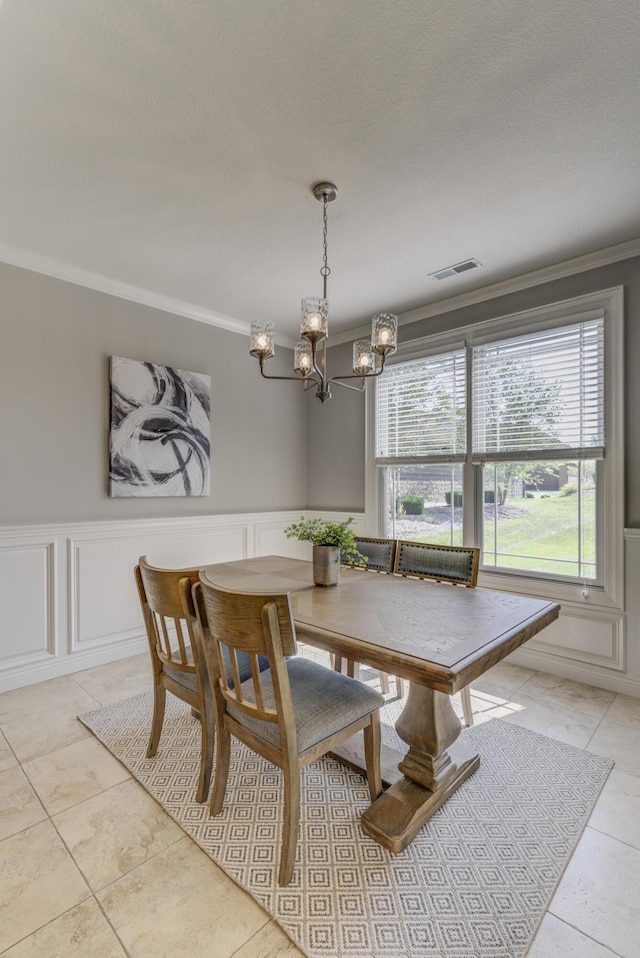 1904 Talco Dr, Columbia, MO 65201 - dining area with a chandelier, ornamental molding, a decorative wall, light tile patterned floors, and a wainscoted wall