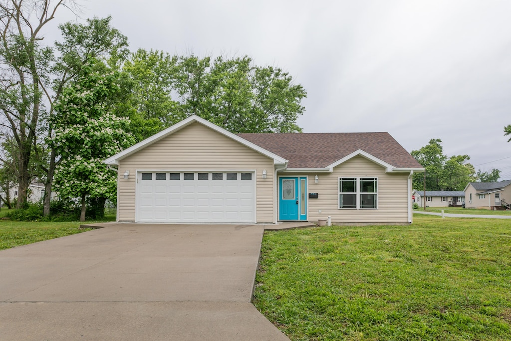 921 N Clark St, Mexico, MO 65265 - single story home with a front lawn, a garage, driveway, and a shingled roof