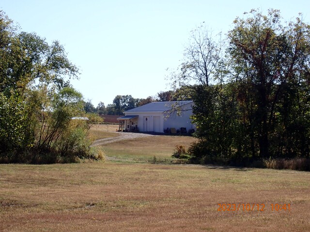 11630 N Varnon School Rd, Hallsville, MO 65255 - view of green lawn with dirt driveway and an attached garage