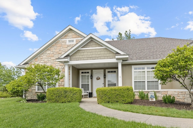 1703 Ballentine Ln, Columbia, MO 65201 - view of front facade with stone siding, a front yard, and a shingled roof