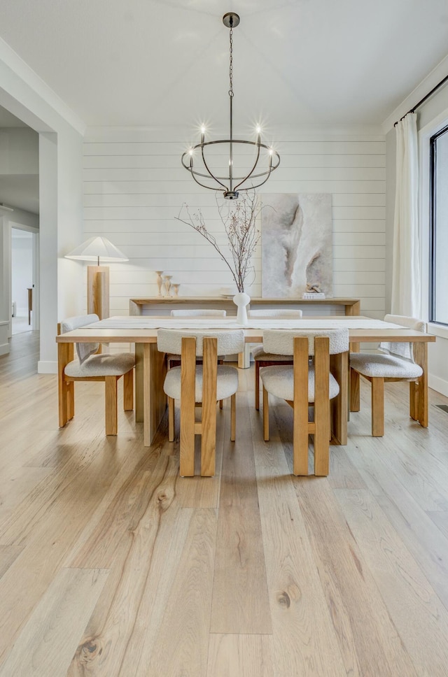 214 Hellwig Ln, Columbia, MO 65203 - dining room with light wood-style flooring, a chandelier, wooden walls, and baseboards