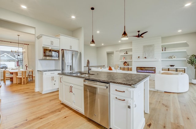 214 Hellwig Ln, Columbia, MO 65203 - kitchen featuring appliances with stainless steel finishes, light wood-type flooring, a sink, an island with sink, and white cabinetry