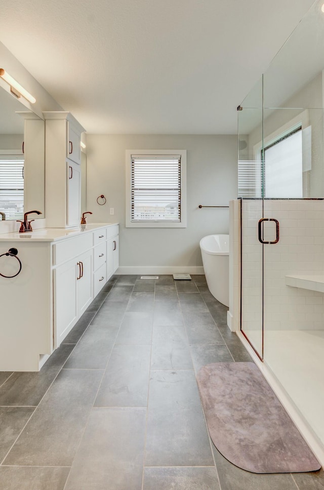 214 Hellwig Ln, Columbia, MO 65203 - bathroom with vanity, a stall shower, a soaking tub, and baseboards