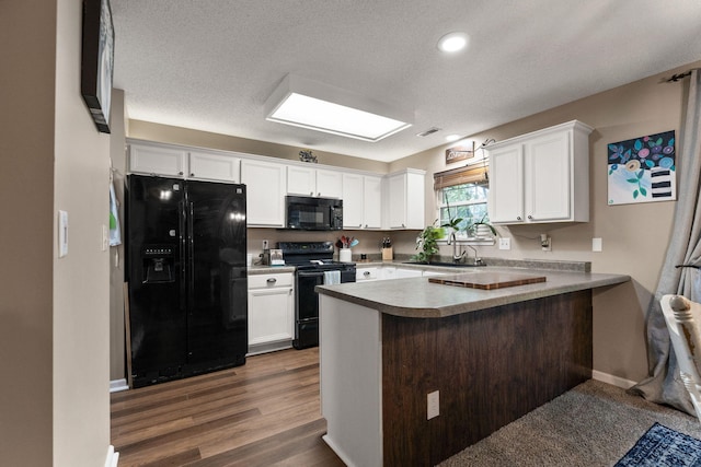 1807 E Phoenix Rd, Columbia, MO 65202 - kitchen with black appliances, a peninsula, white cabinetry, a sink, and baseboards