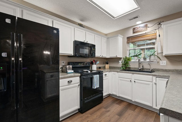 1807 E Phoenix Rd, Columbia, MO 65202 - kitchen with black appliances, a sink, a textured ceiling, white cabinets, and light countertops