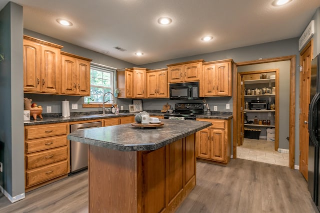 205 Jameson Dr, Ashland, MO 65010 - kitchen with black appliances, a sink, dark countertops, wood finished floors, and recessed lighting