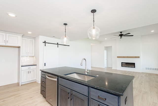 4505 Chambers Bay Dr, Columbia, MO 65201 - kitchen with a sink, a barn door, light wood-style floors, dark stone counters, and recessed lighting