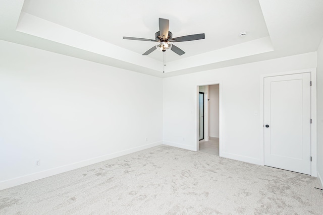 4505 Chambers Bay Dr, Columbia, MO 65201 - spare room featuring a tray ceiling, ceiling fan, light colored carpet, and baseboards