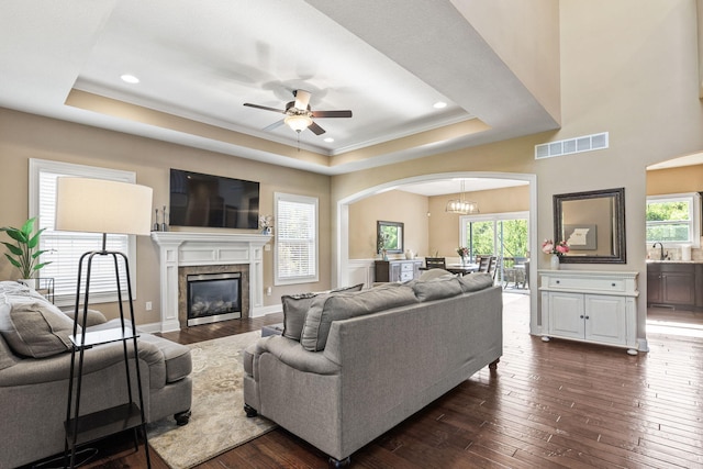 128 Cedar Falls Ct, Columbia, MO 65203 - living room featuring a tray ceiling, arched walkways, dark wood finished floors, a ceiling fan, and healthy amount of natural light