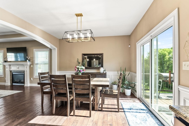 128 Cedar Falls Ct, Columbia, MO 65203 - dining space with hardwood / wood-style floors, healthy amount of natural light, a chandelier, arched walkways, and wainscoting