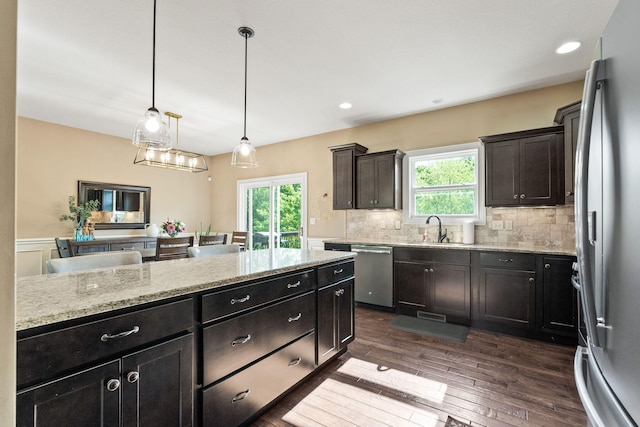 128 Cedar Falls Ct, Columbia, MO 65203 - kitchen with stainless steel appliances, a sink, light stone counters, backsplash, and dark wood-style floors