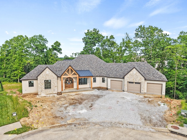 7200 Rudchester Ct, Columbia, MO 65203 - view of front of house featuring stone siding, a garage, driveway, stucco siding, and a standing seam roof