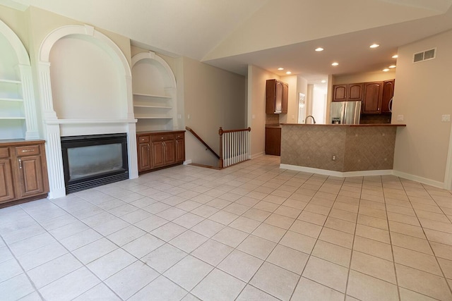 2409 Wild Oak Ct, Columbia, MO 65201 - unfurnished living room featuring recessed lighting, a glass covered fireplace, lofted ceiling, light tile patterned floors, and built in features