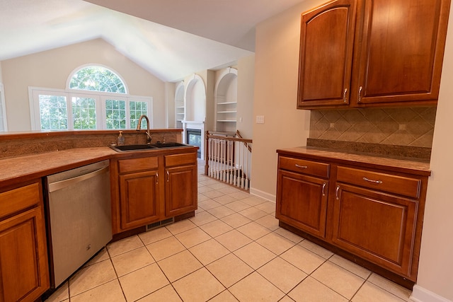 2409 Wild Oak Ct, Columbia, MO 65201 - kitchen with stainless steel dishwasher, lofted ceiling, light tile patterned floors, backsplash, and a fireplace
