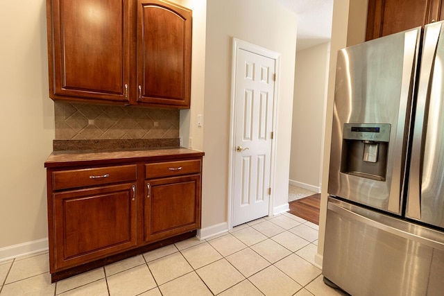 2409 Wild Oak Ct, Columbia, MO 65201 - kitchen with stainless steel fridge, light tile patterned floors, backsplash, and dark countertops
