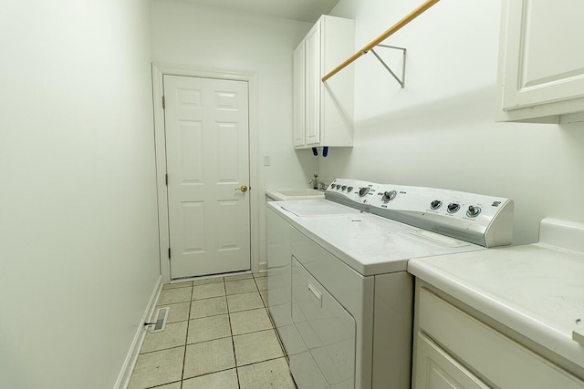 2409 Wild Oak Ct, Columbia, MO 65201 - laundry area with cabinet space, washing machine and clothes dryer, and light tile patterned floors