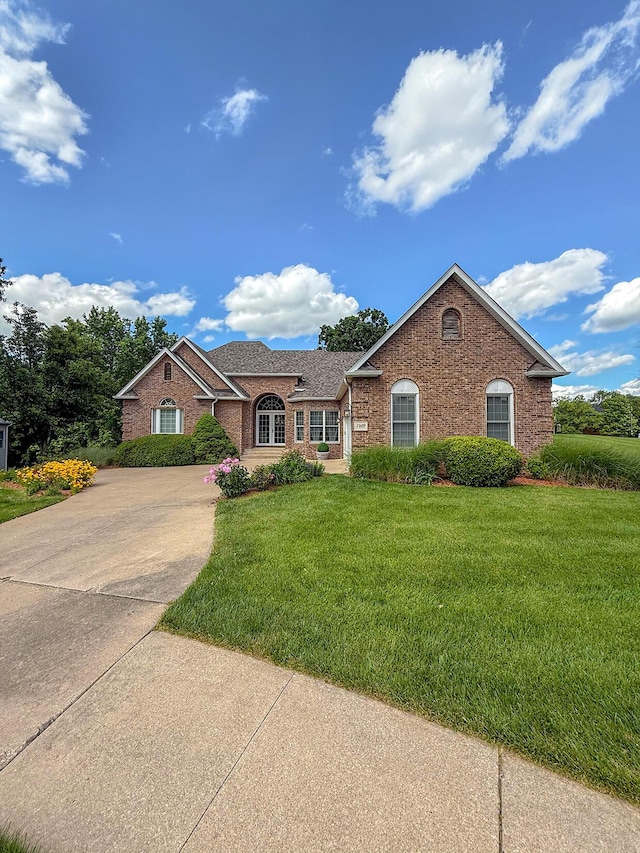 2409 Wild Oak Ct, Columbia, MO 65201 - ranch-style home with brick siding, a front yard, driveway, and a shingled roof