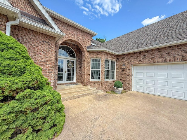 2409 Wild Oak Ct, Columbia, MO 65201 - doorway to property with roof with shingles, brick siding, french doors, and concrete driveway