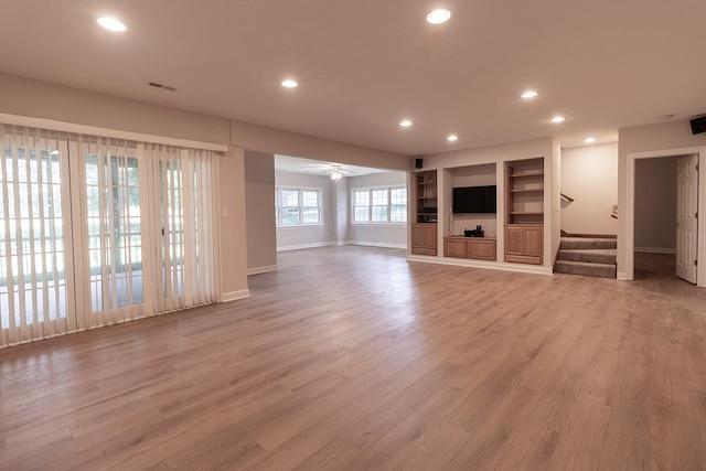 2409 Wild Oak Ct, Columbia, MO 65201 - unfurnished living room with recessed lighting, stairs, light wood-style flooring, a ceiling fan, and built in features