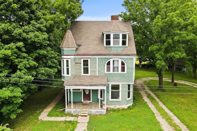 408 Vassar St, Bunceton, MO 65237 - victorian-style house featuring a porch, driveway, a chimney, a front yard, and roof with shingles