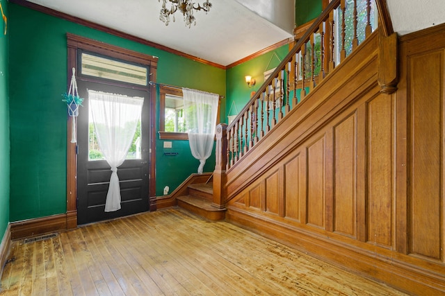 408 Vassar St, Bunceton, MO 65237 - foyer with stairway, a chandelier, wood-type flooring, and crown molding