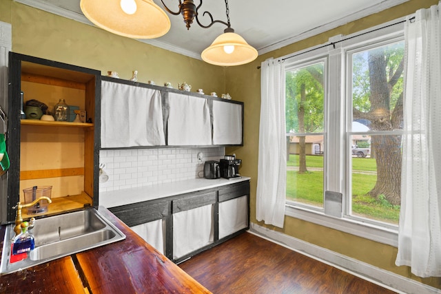 408 Vassar St, Bunceton, MO 65237 - kitchen with decorative backsplash, dark wood-style flooring, ornamental molding, and hanging light fixtures