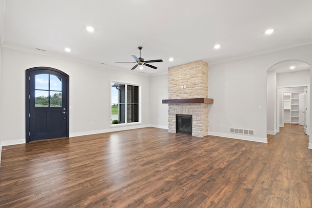6505 Cromford Ln, Columbia, MO 65201 - unfurnished living room with arched walkways, ceiling fan, crown molding, dark wood-style flooring, and a fireplace