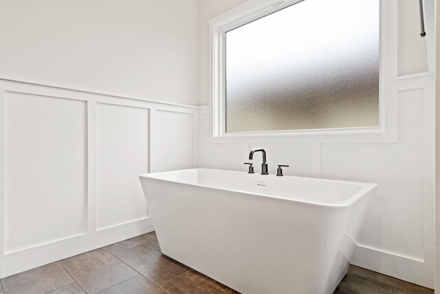 6505 Cromford Ln, Columbia, MO 65201 - full bathroom featuring a decorative wall, a soaking tub, and a wainscoted wall