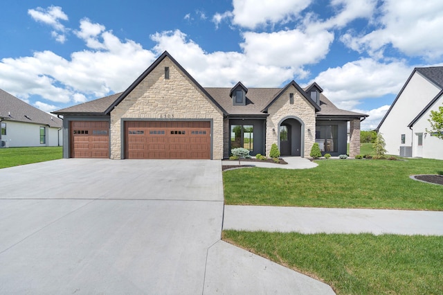 6505 Cromford Ln, Columbia, MO 65201 - french provincial home featuring stone siding, driveway, an attached garage, and a front yard