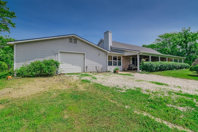 3111 E E W Snowy Hills Ln, Hartsburg, MO 65039 - view of front of house with a chimney, a garage, driveway, and a front lawn
