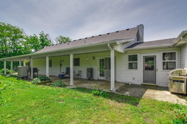 3111 E E W Snowy Hills Ln, Hartsburg, MO 65039 - rear view of house featuring a lawn, a patio, central air condition unit, and a shingled roof