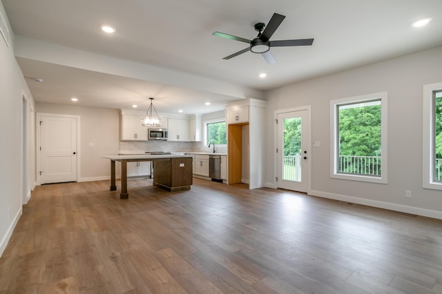 4000 S Felicity Ln, Columbia, MO 65203 - kitchen featuring appliances with stainless steel finishes, a center island, white cabinetry, baseboards, and wood finished floors
