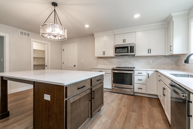 4000 S Felicity Ln, Columbia, MO 65203 - kitchen with stainless steel appliances, a sink, light wood-type flooring, decorative backsplash, and recessed lighting