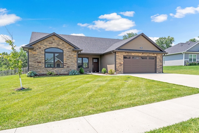 5990 W Tamarack Dr, Columbia, MO 65203 - view of front of home featuring stone siding, a garage, driveway, and a front lawn