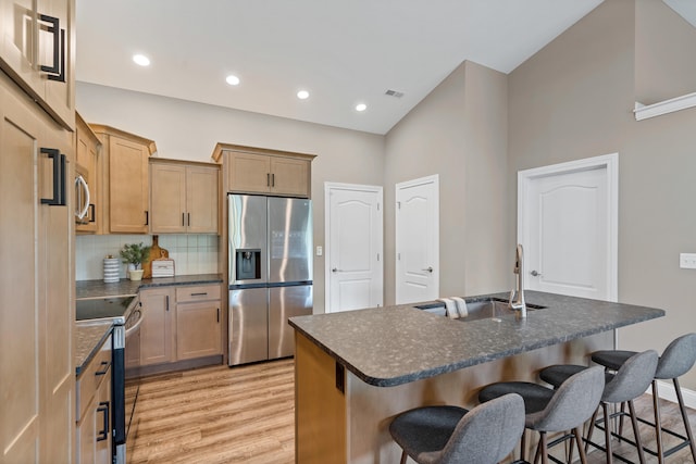 5990 W Tamarack Dr, Columbia, MO 65203 - kitchen featuring appliances with stainless steel finishes, light wood-style floors, a breakfast bar area, tasteful backsplash, and recessed lighting