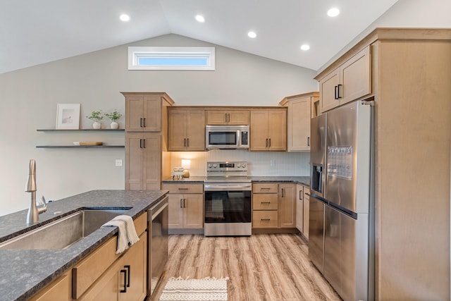 5990 W Tamarack Dr, Columbia, MO 65203 - kitchen featuring appliances with stainless steel finishes, dark stone countertops, light wood-style flooring, high vaulted ceiling, and backsplash