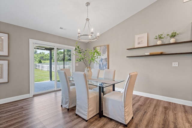 5990 W Tamarack Dr, Columbia, MO 65203 - dining space featuring a chandelier, wood finished floors, and vaulted ceiling