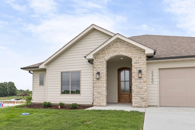 2360 N Federal Dr, Columbia, MO 65202 - view of front facade with an attached garage, roof with shingles, stone siding, and a front lawn