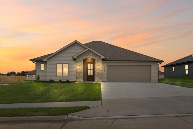 2360 N Federal Dr, Columbia, MO 65202 - view of front facade with a yard, an attached garage, concrete driveway, and stone siding