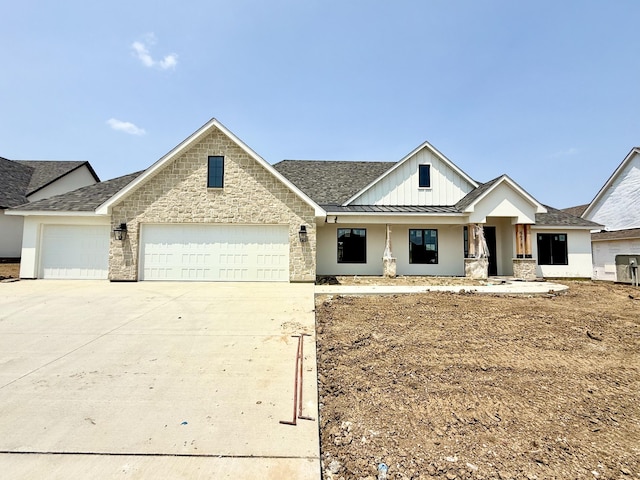 5915 Ivory Ln, Columbia, MO 65201 - view of front of home with a standing seam roof, a garage, driveway, a porch, and metal roof