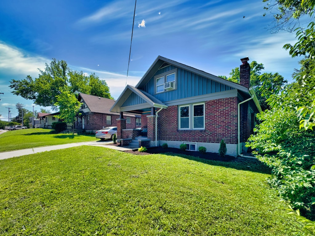 1008 W Broadway, Columbia, MO 65203 - bungalow-style house with brick siding, a chimney, a front lawn, board and batten siding, and cooling unit
