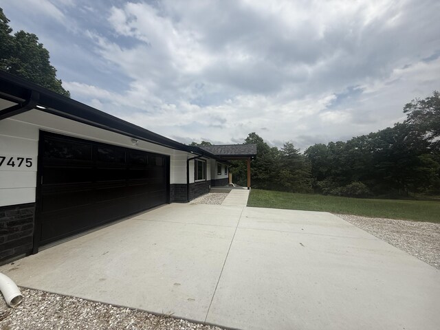 7475 E Lost Woods Ln, Centralia, MO 65240 - view of property exterior with an attached garage and driveway